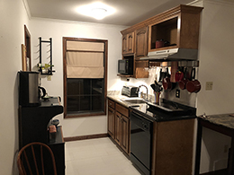 Microwave, toaster oven, two burner cook top are in the kitchen.