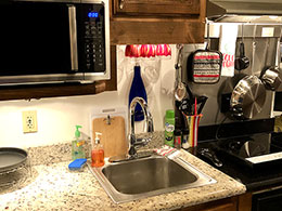 Bar height table & stools, coffee maker and refrigerator.